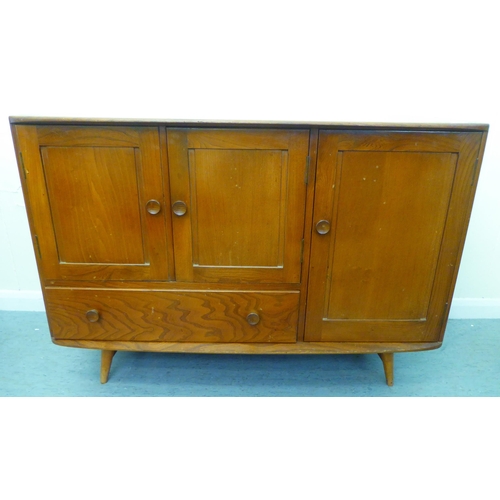 309 - A blonde Ercol elm sideboard with an arrangement of three cupboards and a drawer, raised on tapered ... 