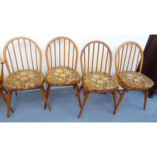 310 - A matched set of six Ercol beech and elm framed dining chairs, comprising four standard/two open arm