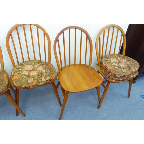 310 - A matched set of six Ercol beech and elm framed dining chairs, comprising four standard/two open arm