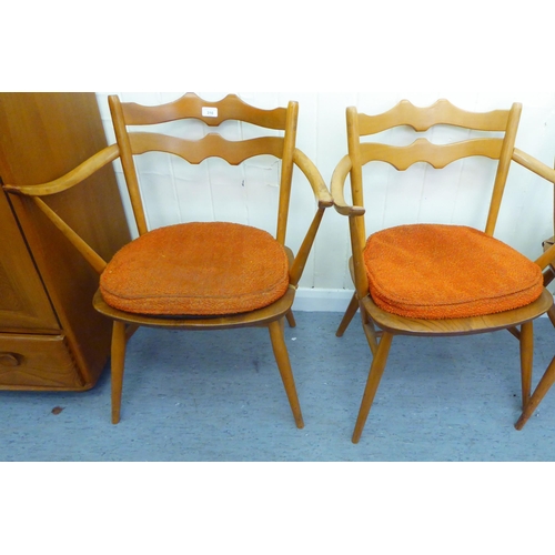 310 - A matched set of six Ercol beech and elm framed dining chairs, comprising four standard/two open arm