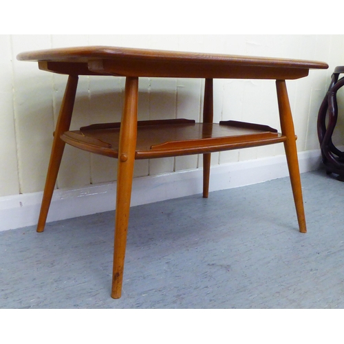 312 - A blonde Ercol elm two tier coffee table, raised on elliptically turned legs  18