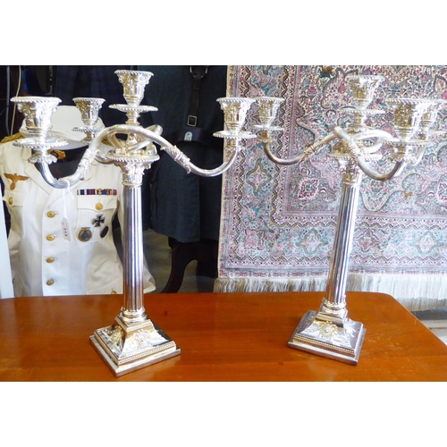 313 - A pair of Edwardian style loaded silver plated Corinthian capital, three branch candelabra, on a ste... 