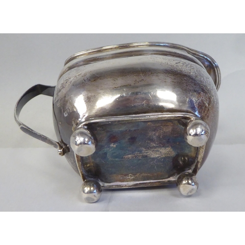 1 - A George III silver oval, ogee shape cream jug with an applied wire rim and loop handle, on ball fee... 