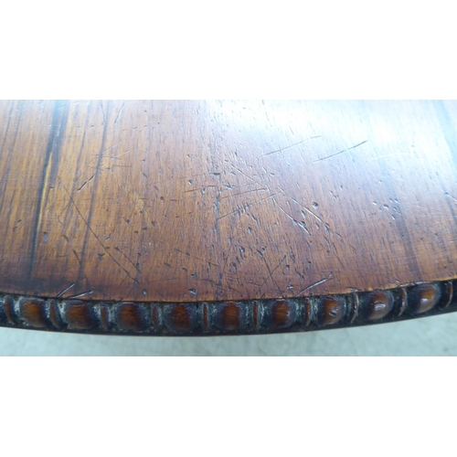 105 - A William IV bead bordered rosewood dining table, the radiating veneered tip-top set on an incurved,... 