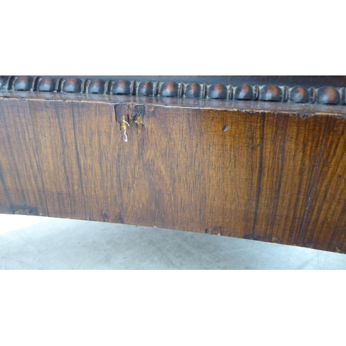 105 - A William IV bead bordered rosewood dining table, the radiating veneered tip-top set on an incurved,... 