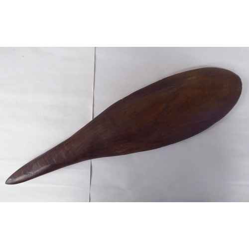 119 - Four Australian/South Pacific native wooden artefacts, viz. a Woomera; a paddle shape throwing club;... 