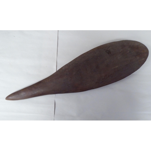 119 - Four Australian/South Pacific native wooden artefacts, viz. a Woomera; a paddle shape throwing club;... 