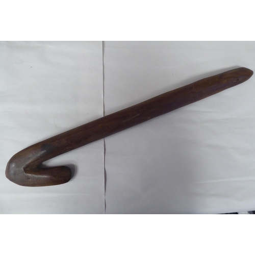 119 - Four Australian/South Pacific native wooden artefacts, viz. a Woomera; a paddle shape throwing club;... 