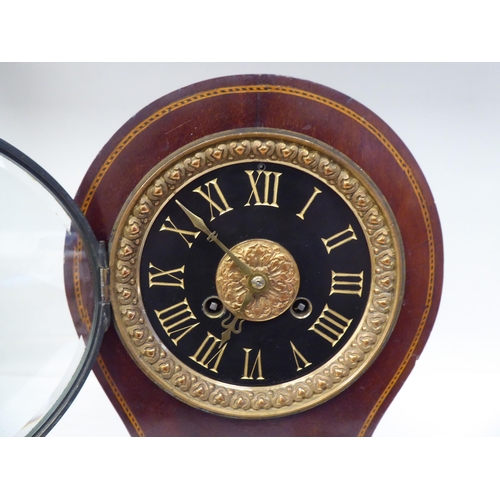 122 - A late Victorian/Edwardian string inlaid mahogany balloon cased mantel clock; the gong strike moveme... 