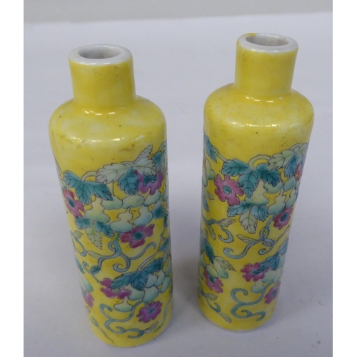 124 - A pair of late 19th/early 20thC Chinese porcelain bottle vases, decorated in coloured famille rose, ... 