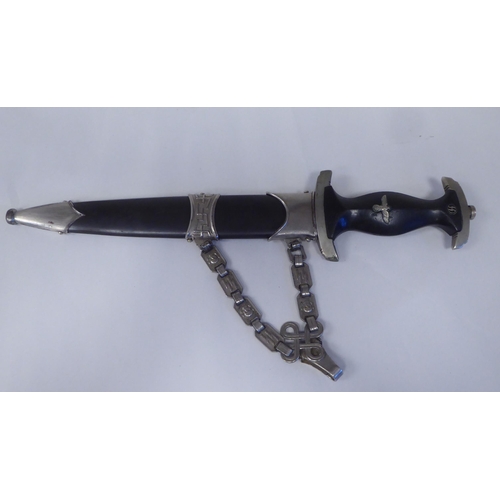 126 - A Third Reich era 'chained' SS dress dagger with a shaped handgrip, nickel-silver mounts and a cross... 