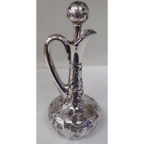 130 - A glass wine decanter of bottle form with a bulbous body, long, narrow neck, loop handle and stopper... 