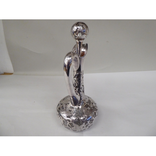 130 - A glass wine decanter of bottle form with a bulbous body, long, narrow neck, loop handle and stopper... 