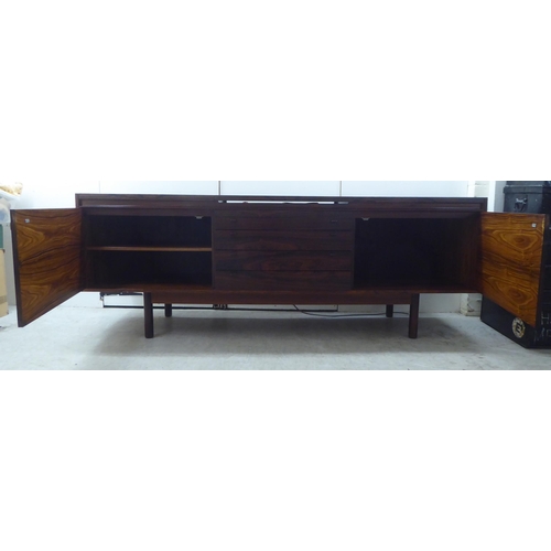 135 - Attributed to Robert Heritage for Archie Shine, a 1960s rosewood sideboard, the top with a rising an... 