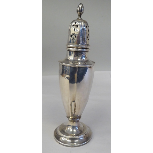 151 - A silver pedestal caster with a domed cover; and a silver sauce boat, having a C-scrolled handle, on... 