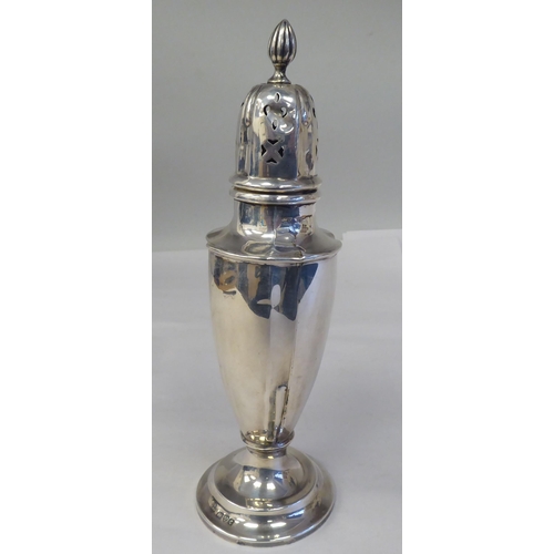 151 - A silver pedestal caster with a domed cover; and a silver sauce boat, having a C-scrolled handle, on... 