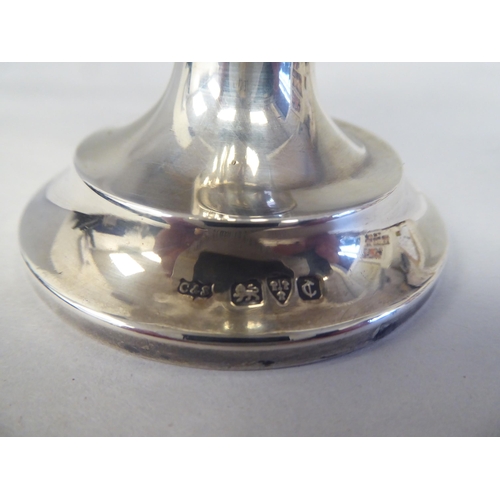 151 - A silver pedestal caster with a domed cover; and a silver sauce boat, having a C-scrolled handle, on... 