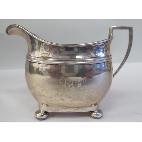 161 - A three piece silver tea set of oval, bulbous form, on bun feet, comprising a teapot with a swept sp... 