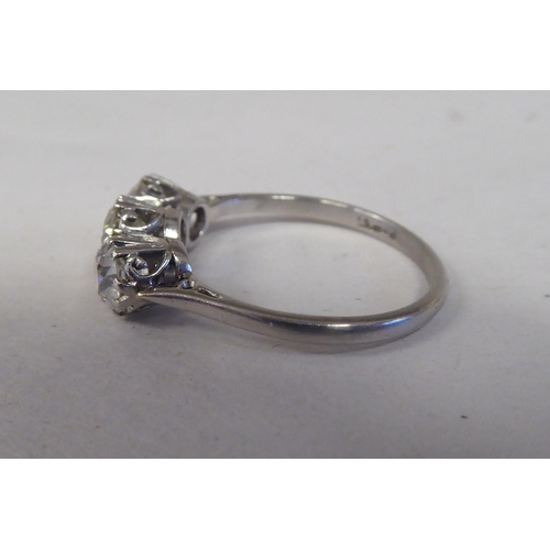 164 - A white coloured metal three stone claw set diamond ring 