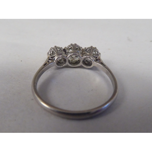 164 - A white coloured metal three stone claw set diamond ring 