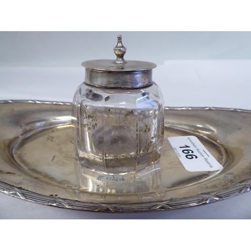 166 - A silver inkstand of boat design with a cut glass reservoir and hinged cap  James Deakin & ... 