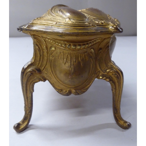 167 - A late 19thC cast gilded metal jewellery box, fashioned as a commode, the hinged lid enclosing a qui... 