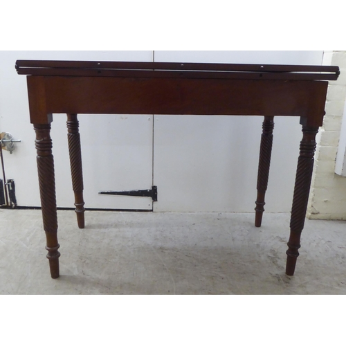 173 - An early 19thC mahogany tea table with a foldover top, raised on turned ropetwist legs  31