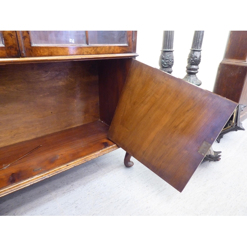 176 - A mid 20thC walnut bookcase with two glazed doors and two panelled doors, raised on cabriole legs&nb... 