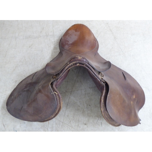 188 - Two brown hide horse saddles; and another in black hide