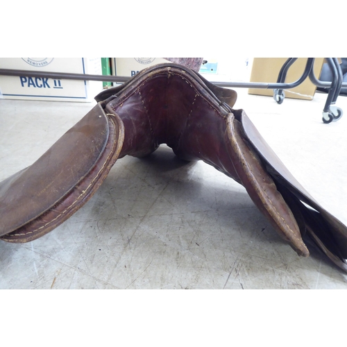 188 - Two brown hide horse saddles; and another in black hide