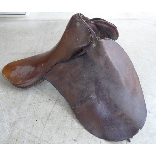 188 - Two brown hide horse saddles; and another in black hide