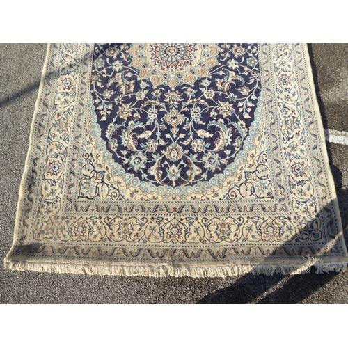 190 - An Iranian Nain woollen rug with stylised motifs, on a beige ground  120