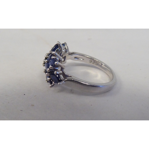 192 - A white metal cluster ring, set with oval cut sapphires  stamped 925