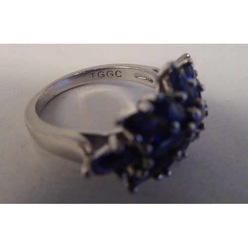 192 - A white metal cluster ring, set with oval cut sapphires  stamped 925