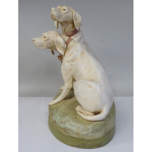 20 - A Royal Dux porcelain model, a pair of seated hounds, on an oval, naturalistically moulded plinth, i... 