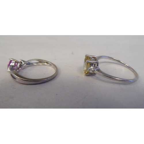 204 - Two white metal rings, one set with a yellow citrine, the other with a pink heart shaped stone 