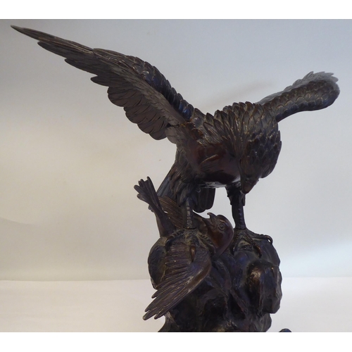 208 - A cast and patinated bronze model eagle, on a rock with captured prey  16