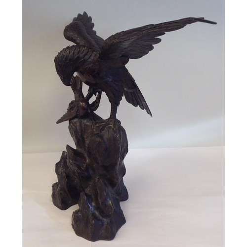 208 - A cast and patinated bronze model eagle, on a rock with captured prey  16