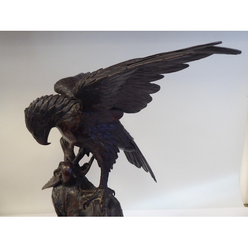 208 - A cast and patinated bronze model eagle, on a rock with captured prey  16