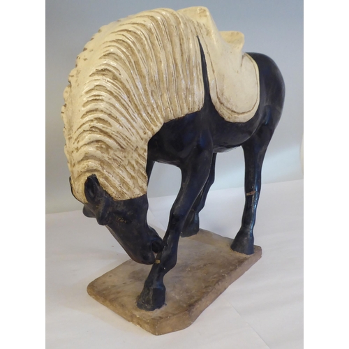 209 - In the manner of a Jang, black and cream coloured glazed pottery model, a standing horse, on a plint... 