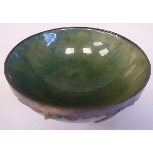 26 - A 20thC Chinese green jadeite bowl, set in a white metal frame  4.25