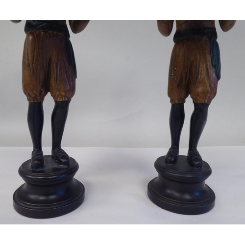 31 - A pair of painted cold cast bronze blackamoor figures, featuring two boys, wearing turbans, each car... 