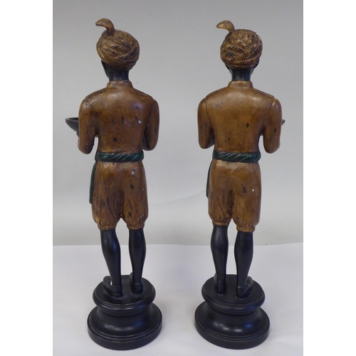 31 - A pair of painted cold cast bronze blackamoor figures, featuring two boys, wearing turbans, each car... 