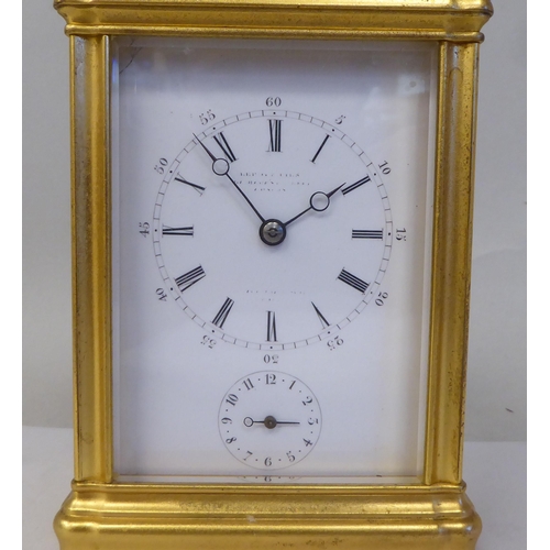 34 - An early 20thC French lacquered brass cased carriage clock with a folding top handle and bevelled gl... 