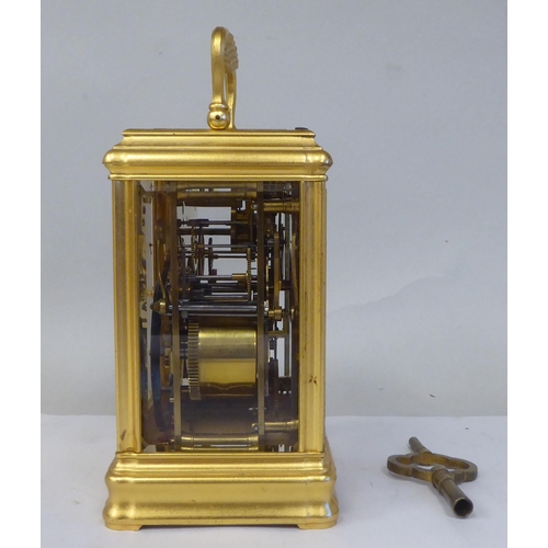 34 - An early 20thC French lacquered brass cased carriage clock with a folding top handle and bevelled gl... 