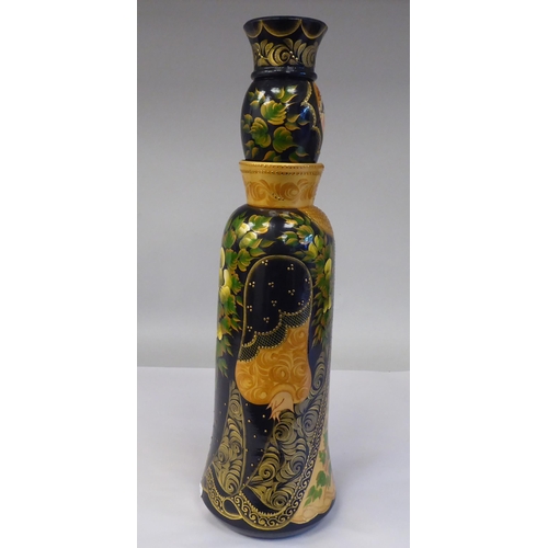 36 - A Russian turned and painted softwood bottle vase, featuring a young woman wearing traditional costu... 