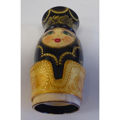 36 - A Russian turned and painted softwood bottle vase, featuring a young woman wearing traditional costu... 