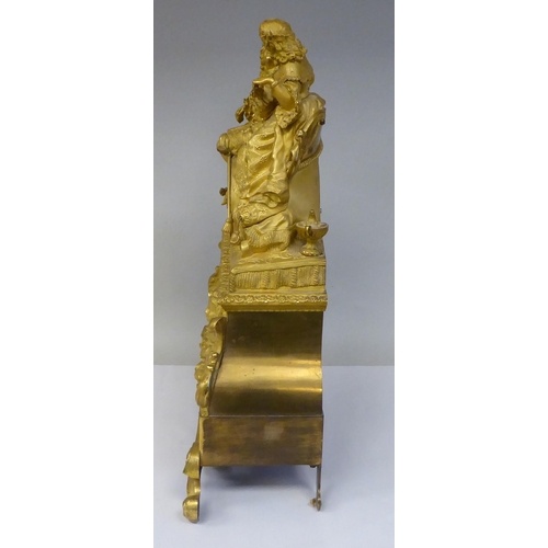 42 - A 19thC French gilt metal cased mantel clock, featuring a seated couple, on a draped cushion, the de... 