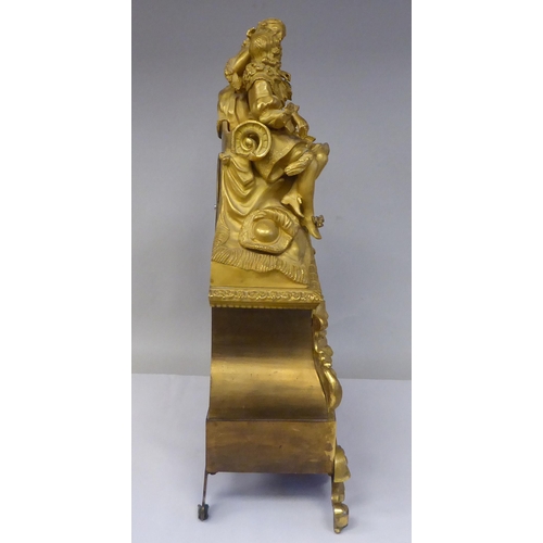 42 - A 19thC French gilt metal cased mantel clock, featuring a seated couple, on a draped cushion, the de... 