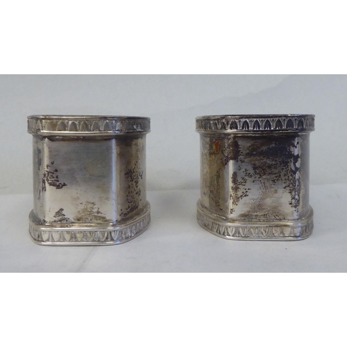 5 - A set of eight silver coloured metal oval napkin rings with egg and dart cast borders  bearing ... 